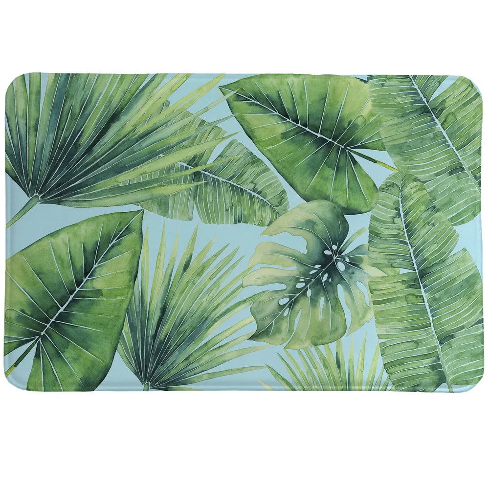 Tropical Palm Tree Leaves Memory Foam Rug features palms, fronds and banana leaves in a watercolor technique set before a blue backdrop.